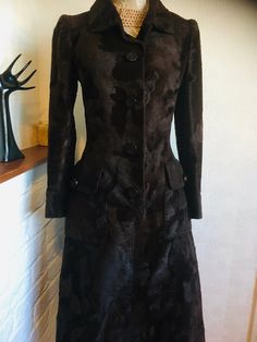 A gorgeous vintage coat dress in dark brown by Hardy Amies Boutique. This beautifully tailored coat dress features slight puff long sleeves with cuff and buttons, single breasted open front with matching plastic buttons and a hook, two large pockets with flaps and button detail, two pleats at the back and full lining. The main fabric has a texture to it like faux fur.  A fabulous 50's-60's coat dress to define its era.   **In 1945, Sir Hardy Amies was already a well-known designer of Women's hou Fitted Long-sleeved Fur Coat For Evenings, Fitted Long Sleeve Fur Coat For Evening, Brown Long Sleeve Evening Outerwear, Brown Long-sleeved Outerwear For Evening, Brown Long Sleeve Outerwear For Evening, Brown Winter Evening Outerwear, Brown Fitted Long Fur Coat, Vintage Long Coat For Party, Winter Dress Coat