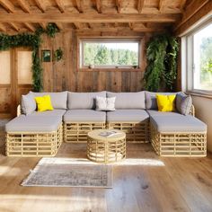 a living room filled with lots of furniture and wooden flooring next to a window