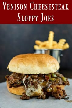 a close up of a sandwich on a plate with fries in the background and text overlay that reads, venison cheesesteak sloppy joes