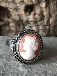 A traditional Silver vintage bezel set Cameo ring, oval Cameo 12 x 11mm ,with a border of Marcasite with an overall size of 16mm x 15mm , Size I 1/2 or US 4.5 Victorian Oval Filigree Ring With Cabochon, Vintage Filigree Ring With Cabochon, Classic Oval Cameo Rings, Vintage Oval Cameo Ring, Antique Filigree Ring With Cabochon, Antique Silver Cameo Rings, Vintage Antique Silver Oval Ring, Vintage Oval Antique Silver Rings, Victorian Silver Cameo Rings