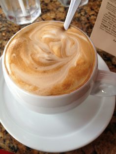 a cappuccino is sitting on a saucer