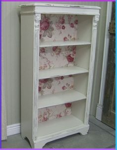 a white bookcase with pink flowers on it