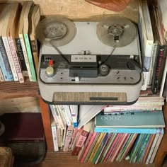 an old radio sitting on top of a book shelf filled with books