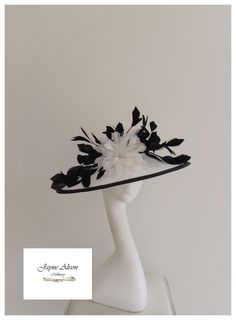 'Angled headpiece with shallow angled crown in winter white sinamay, with a black bias on the brim and crown, create this striking headpiece.  A white feather flower takes centre stage whilst a black 'feather tree' twists and turns around the brim and crown, creating a striking effect.   Sits on a headband.  'This item has sold, however, similar pieces can be made in a variety of colours.  Please ask for details.  As every piece is handmade, some differences can occur from the photos listed on t Black Cloche Wedding Hats And Headpieces, Black Cloche Wedding Hat, Black Curved Brim Top Hat For Wedding, Black Cloche Costume Hat For Wedding, Black Curved Brim Costume Hat For Weddings, Black Mini Hat With Curved Brim For Wedding, Black Boater Hat For Royal Ascot Wedding, Black Brimmed Top Hat For Wedding, Black Boater Hat For Wedding At Royal Ascot