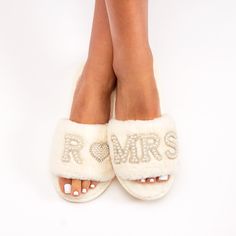 a woman's feet wearing white slippers with the word romas written on them