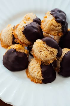 a white plate topped with chocolate covered donuts