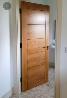 an open wooden door in a white room