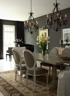 an elegant dining room with chandelier and piano in the backround area