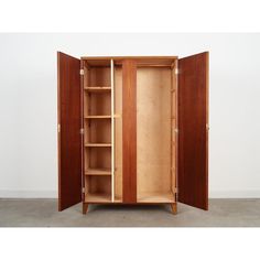 an open wooden cabinet with shelves on both sides and two doors at the top, in front of a white wall