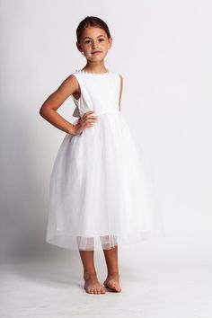 This gorgeous dress features a very elegant, yet simple, style! Woven cotton bodice is comfortable, and dressed up with hand placed large pearl beads! A very full tulle skirt with tea length hemline adds a bit of vintage charm, while the open back is a show stopper! This gown is fully lined in 100% Elegant Flower Girl Dress, White Tulle Dress, Tule Rok, Blessing Dress, Elegant Girls, White Flower Dress, Girls Tulle Dress, Full Tulle Skirt, Ivory Gown