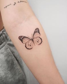 a woman's arm with a small butterfly tattoo on the left side of her arm