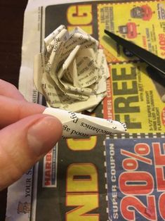 a person is cutting up newspaper with scissors