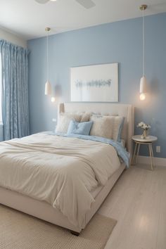 a bedroom with blue walls and white bedding