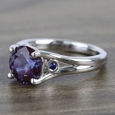 a ring with an oval shaped amethorate and two blue sapphire stones on it