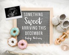 there is a sign that says something sweet about arriving this december and some baby shoes