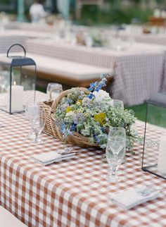 the table is set with flowers and place settings for guests to sit down at it