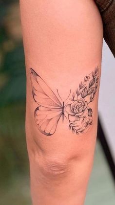 a woman's leg with a butterfly and flowers tattoo on the side of her thigh