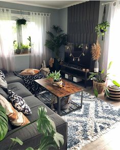 a living room filled with lots of furniture and plants on top of it's tables