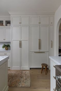 a kitchen with white cabinets and an area rug on the floor in front of it