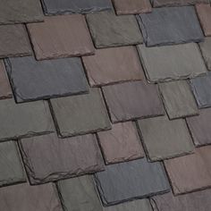 a close up view of some tiles on a building's roof with different colors