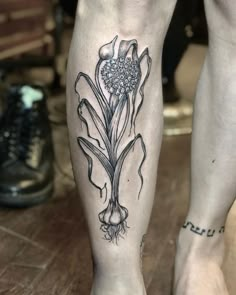 a person's leg with a flower tattoo on it