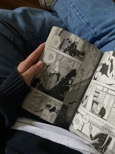 a person is holding an open comic book