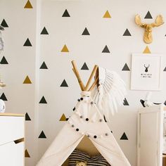 a teepee tent in the corner of a room with black and white wallpaper