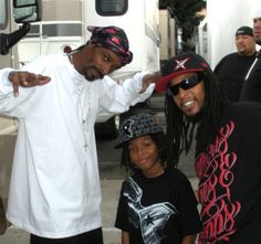 a man and two children standing in front of a white truck with other people around him