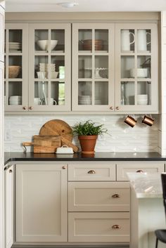 a kitchen with white cabinets, black counter tops and wooden utensils on the counters