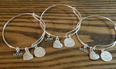 "Handmade 3pc Grandma, Mom & Daughter Family's Love Engraved Bracelet Set ~ Sterling silver plated round charm is engraved with \"A family's love is forever\" in the middle, and \"A family is a circle of love\" on the outer edge. ~ Silver plated heart charm measures 1/2 inch and are engraved with Mom, Daughter and Grandma. And a script charm that says \"Love\" ~ Made with high quality clasp rings to prevent loss of charms ~ Silver plated adjustable wire bangle bracelet fits wrists 6\" to 8\" Adjustable Charms Bracelet For Gift Making, Adjustable Charms Bracelets As Gifts, Adjustable Charms Bracelets For Gifts, Silver Bracelet Jewelry For Gift Making, Christmas Gifts Mom, Mom Daughter Jewelry, Grandma Bracelet, Daughter Bracelet, Love Is Forever