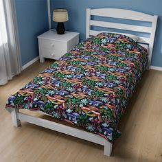 a bed with a colorful bedspread on top of it next to a night stand