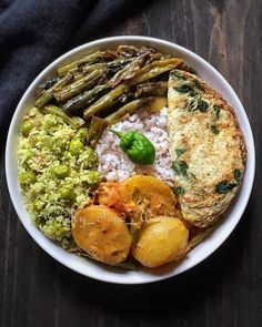 a white bowl filled with food on top of a wooden table