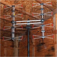 several antennas are attached to the ceiling in a room with wooden walls and plywood flooring