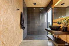 a bathroom with a sink, mirror and shower stall in the corner next to a window