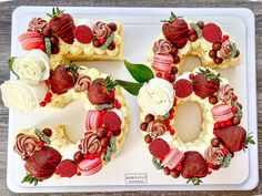 a number shaped cake with strawberries and other toppings sitting on a white plate