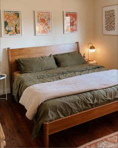 a large bed sitting in a bedroom next to two pictures on the wall above it