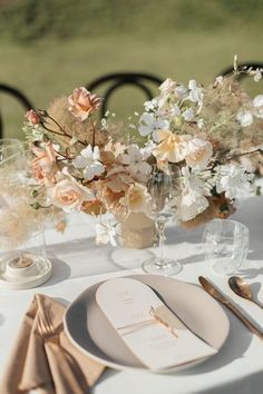 the table is set with flowers and silverware