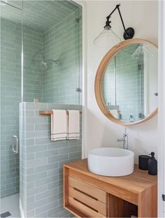 a bathroom with a sink, mirror and shower stall