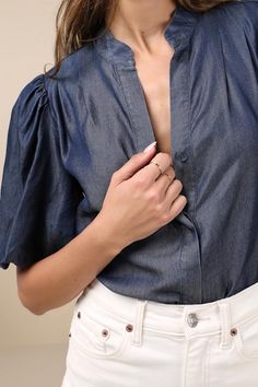 Bring a chic vibe to your everyday looks with the Lulus Contemporary Crush Dark Blue Chambray Puff Sleeve Button-Up Top! Lightweight woven chambray fabric shapes this stylish top that has pleated-like detailing at the shoulders and short puff sleeves with elastic at the cuffs. Crew neckline tops a functional, hidden button placket that runs down the bodice to rounded hems. Fit: This garment fits true to size. Length: Size medium measures 25" from shoulder to hem. Bust: Great for any cup size. Wa Denim Blue Button-up Workwear Blouse, Fitted Denim Top For Workwear, Chambray Denim Top For Workwear, Blue Puff Sleeve Top For Workwear, Blue Puff Sleeve Top For Work, Chic Summer Tops With Back Button Closure, Chic Short Sleeve Denim Top For Day Out, Denim Blue Chambray Top With Button Closure, Chambray Denim Blue Top With Button Closure