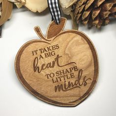 an apple shaped ornament that says it takes a big heart to shape little minds