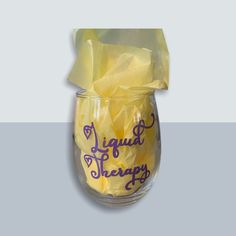 a glass jar with tissue paper wrapped around it and the words liquid therapy written on it