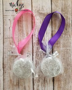 two bags filled with white and purple candies sitting on top of a wooden table