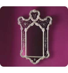 an ornate mirror on a purple wall with beaded trimmings and beads around the edges