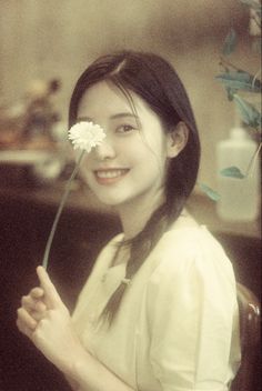 a woman holding a flower in her hand