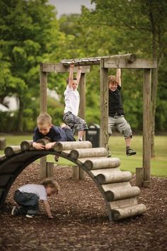 three children playing on a wooden play structure