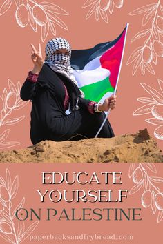 a woman sitting on top of a sandy hill holding a flag in front of her face