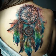 the back of a woman's shoulder with a colorful dream catcher tattoo