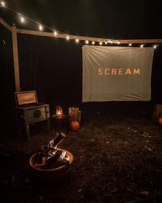 an outdoor area with lights and a sign that says scream on the wall above it