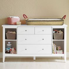 a baby crib with baskets and toys on it's shelf next to a wall