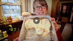 a woman holding up a plastic container filled with food